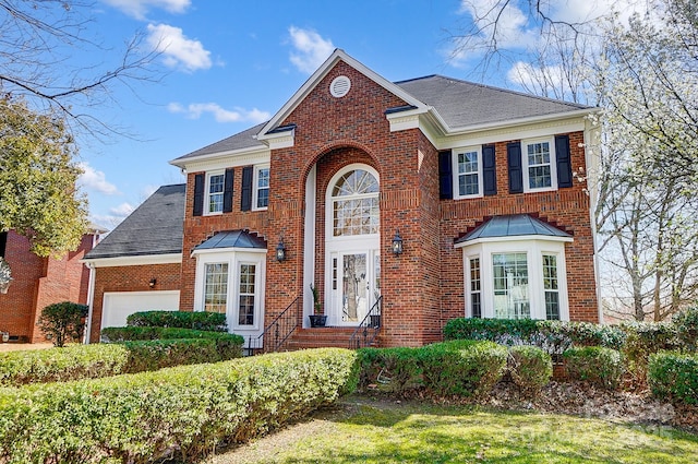 view of front of property featuring brick siding, an attached garage, and a shingled roof