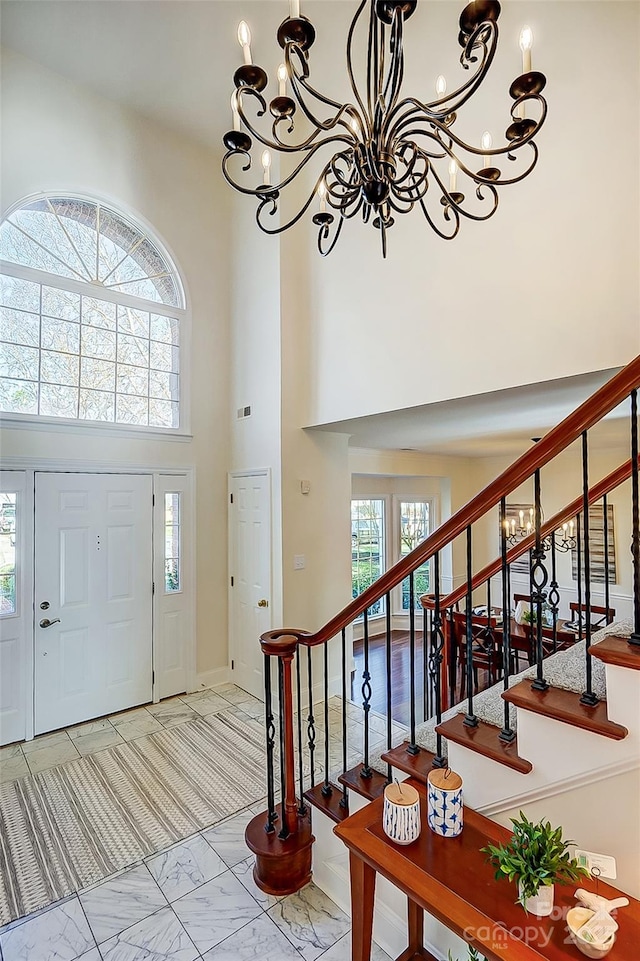 foyer featuring visible vents, a high ceiling, marble finish floor, and stairs