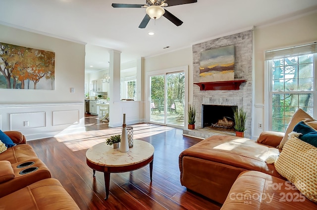 living area featuring a wealth of natural light, wood finished floors, and crown molding