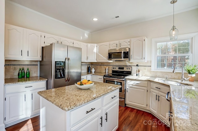 kitchen with a sink, appliances with stainless steel finishes, white cabinets, light stone countertops, and dark wood-style flooring