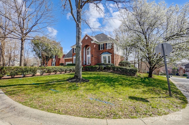 view of front of home with a front lawn and brick siding