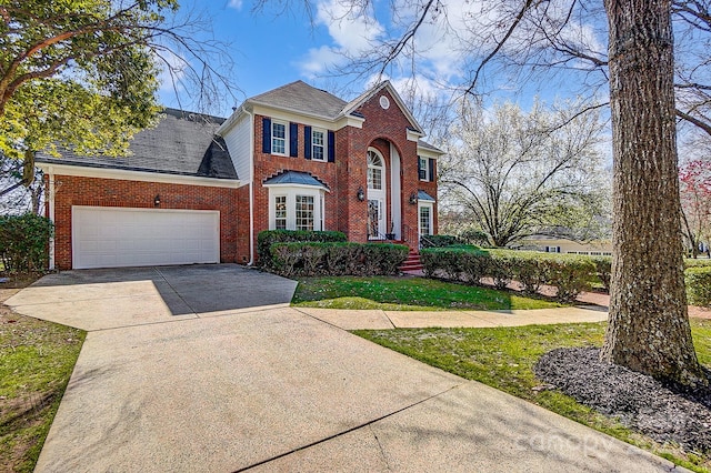 view of front of house with an attached garage, brick siding, driveway, and a shingled roof