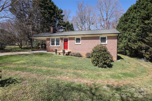 single story home featuring brick siding, an attached carport, a chimney, and a front yard