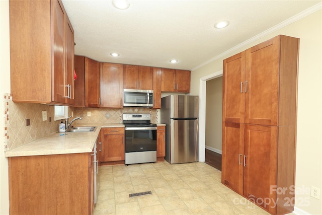 kitchen with visible vents, a sink, appliances with stainless steel finishes, light countertops, and decorative backsplash