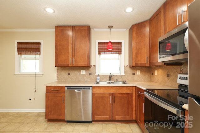 kitchen featuring light countertops, brown cabinetry, appliances with stainless steel finishes, and a sink