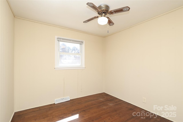 unfurnished room featuring dark wood finished floors, visible vents, and ceiling fan