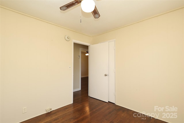 spare room featuring dark wood-type flooring and ceiling fan