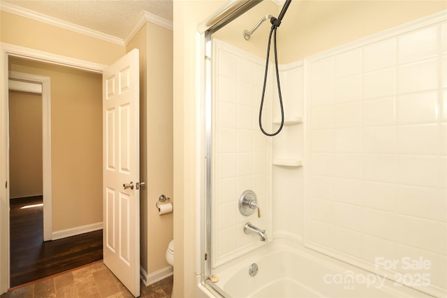 bathroom with toilet, a textured ceiling, shower / bathtub combination, and baseboards