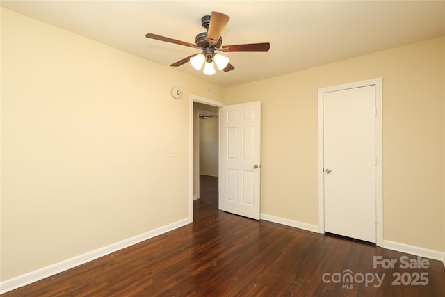 unfurnished bedroom with a ceiling fan, baseboards, and dark wood-style flooring