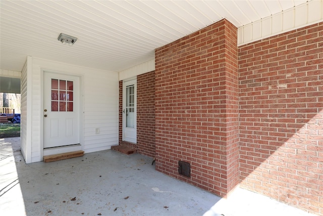 view of exterior entry featuring brick siding