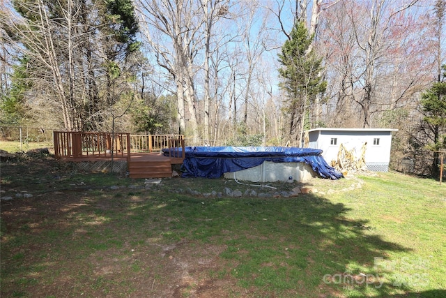 view of yard featuring a covered pool and a wooden deck