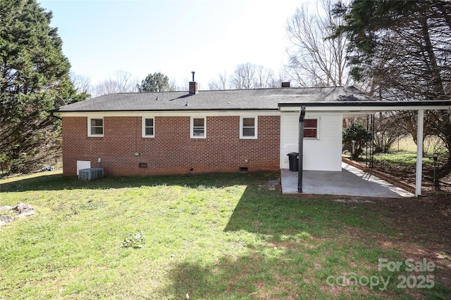 back of property with central air condition unit, a patio, a yard, crawl space, and brick siding