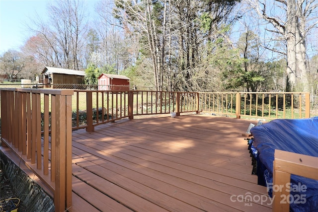 deck featuring an outdoor structure and a shed