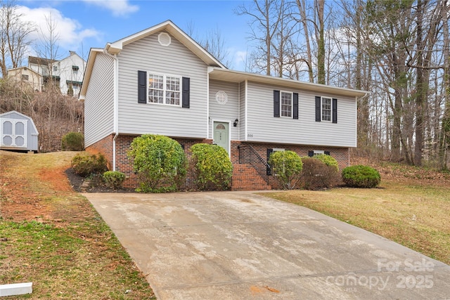 split foyer home featuring brick siding, stairway, a front yard, a storage shed, and an outbuilding