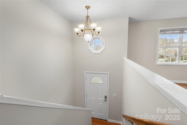 foyer entrance featuring a notable chandelier and baseboards