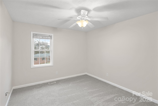 empty room with baseboards, carpet, visible vents, and ceiling fan