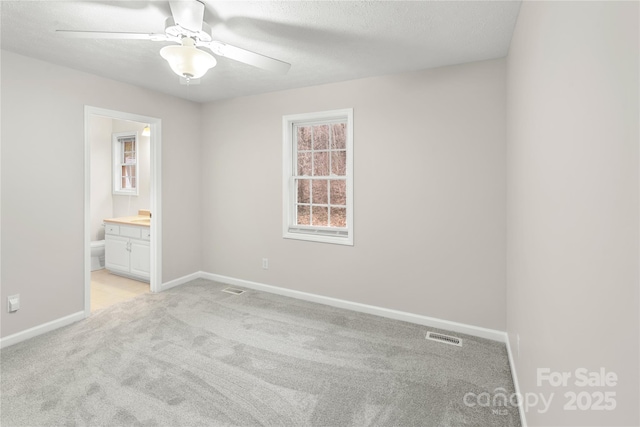 unfurnished bedroom featuring visible vents, baseboards, and light colored carpet