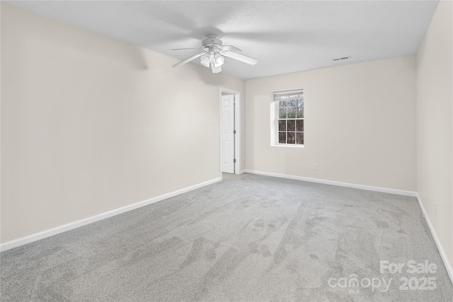 carpeted empty room featuring visible vents, baseboards, and ceiling fan