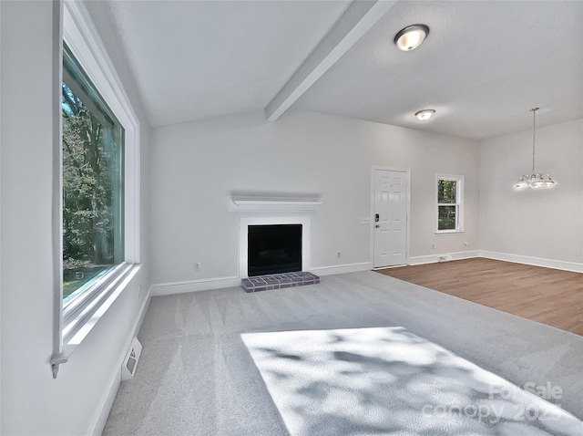 unfurnished living room with visible vents, baseboards, carpet floors, vaulted ceiling with beams, and a fireplace with raised hearth