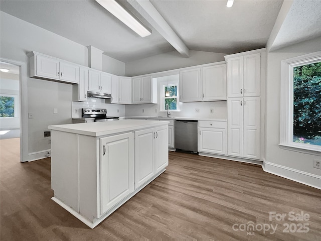 kitchen featuring lofted ceiling with beams, a sink, wood finished floors, white cabinetry, and stainless steel appliances