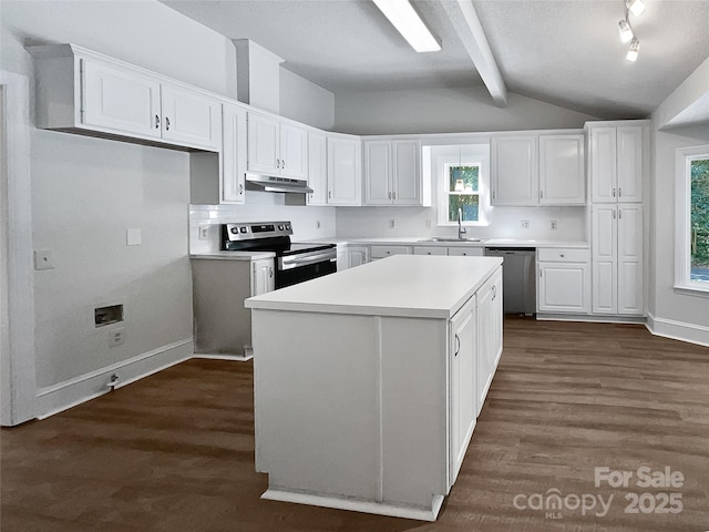 kitchen with under cabinet range hood, dark wood finished floors, lofted ceiling with beams, appliances with stainless steel finishes, and white cabinets