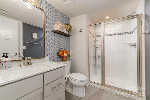 full bathroom with vanity, visible vents, tile patterned flooring, a shower stall, and toilet