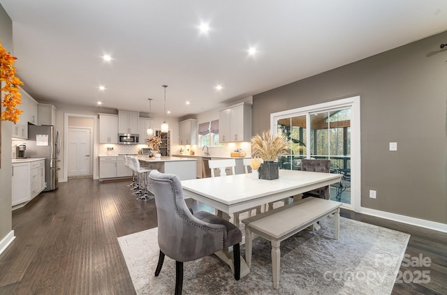 dining room with dark wood-type flooring, recessed lighting, and baseboards