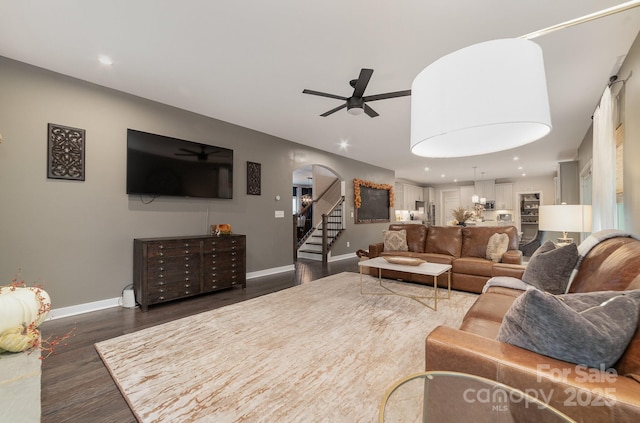 living room featuring dark wood-style floors, recessed lighting, arched walkways, baseboards, and ceiling fan