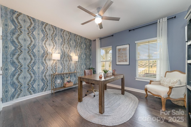 office space with wood finished floors, wallpapered walls, baseboards, ceiling fan, and an accent wall