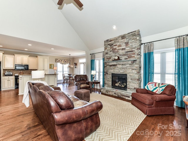 816 Springs Rd, Dallas, NC 28034 - living room featuring a ceiling fan, wood finished floors, high vaulted ceiling, a stone fireplace, and a chandelier