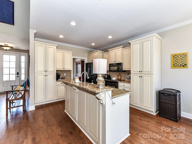 816 Springs Rd, Dallas, NC 28034 - kitchen with cream cabinetry, black microwave, crown molding, light stone countertops, and a kitchen island with sink