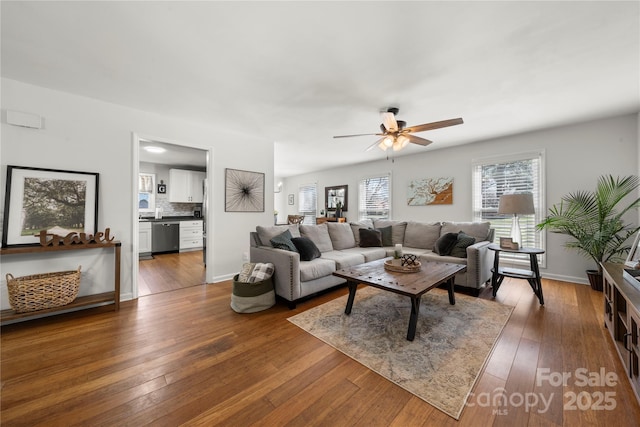 living room featuring dark wood-style floors, baseboards, and ceiling fan