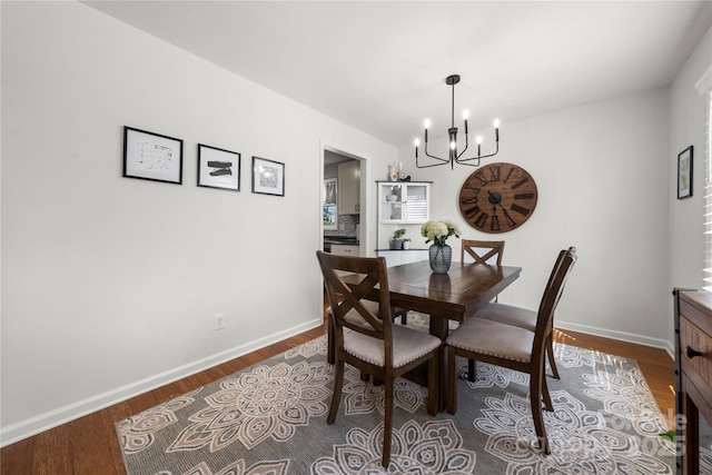 dining room featuring baseboards, an inviting chandelier, and dark wood finished floors