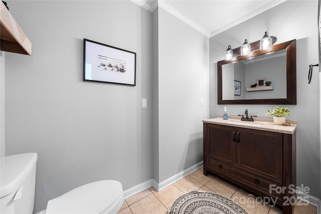 bathroom with tile patterned floors, toilet, ornamental molding, baseboards, and vanity