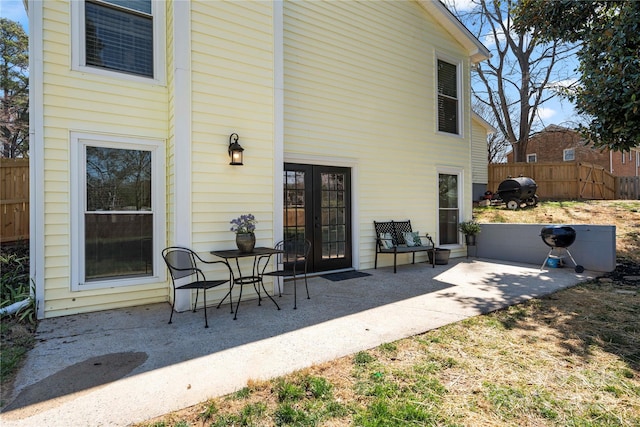 rear view of house featuring a patio area, fence, and french doors