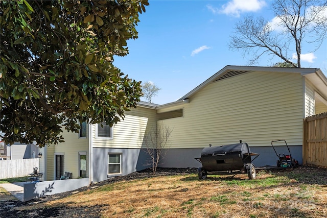 view of side of home featuring fence