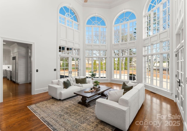 living room featuring visible vents, crown molding, french doors, a towering ceiling, and dark wood-style flooring