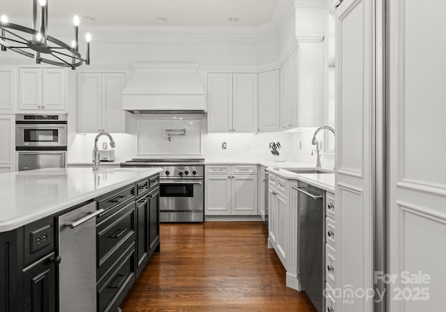 kitchen featuring dark cabinets, white cabinetry, stainless steel appliances, and premium range hood