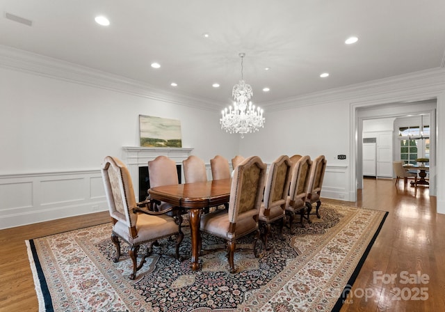 dining room featuring visible vents, ornamental molding, wood finished floors, recessed lighting, and a chandelier