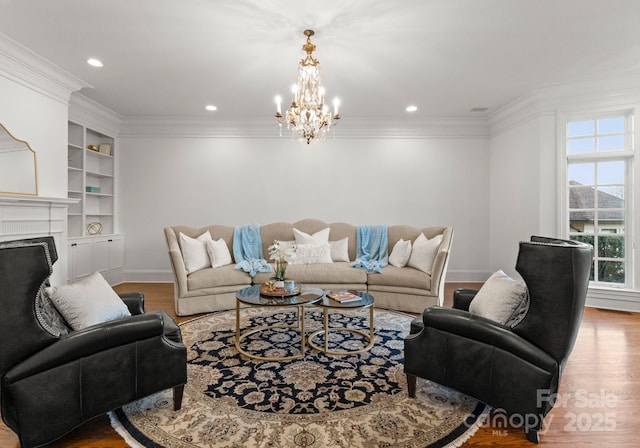 living area with built in shelves, baseboards, ornamental molding, a fireplace, and wood finished floors