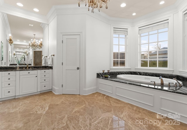 full bathroom featuring vanity, a bath, crown molding, a notable chandelier, and marble finish floor