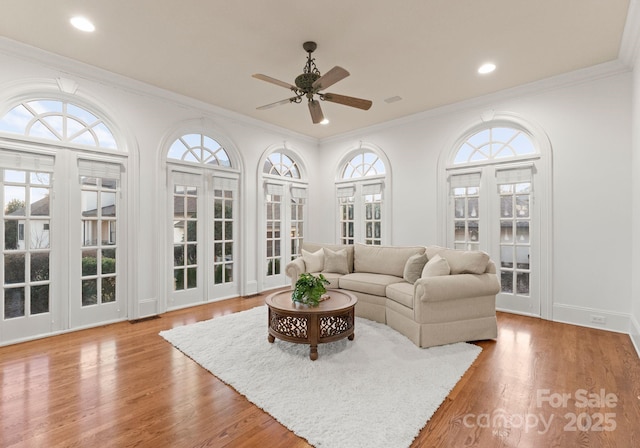 living area with recessed lighting, crown molding, ceiling fan, and wood finished floors