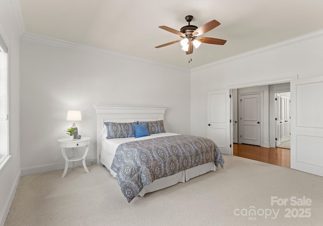 carpeted bedroom with ceiling fan, baseboards, and ornamental molding