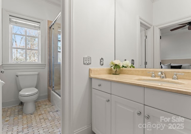 bathroom with toilet, a ceiling fan, combined bath / shower with glass door, baseboards, and vanity