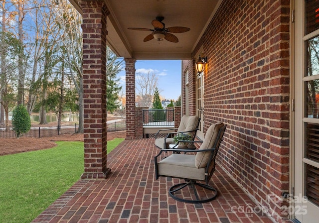 view of patio featuring ceiling fan and fence