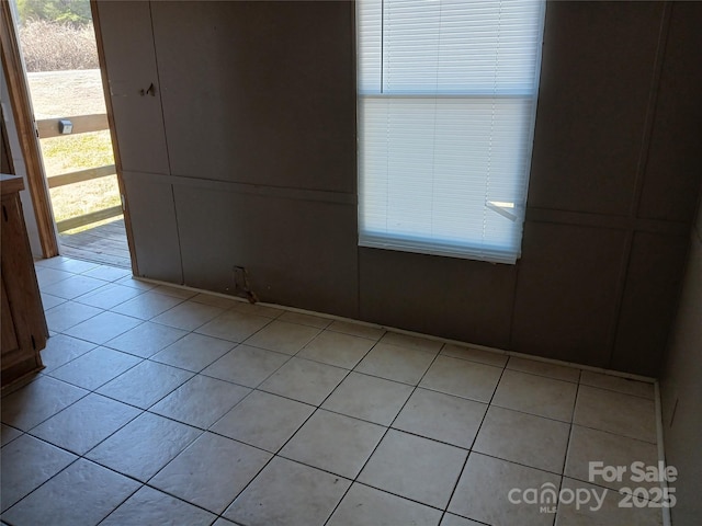 spare room featuring plenty of natural light and light tile patterned floors