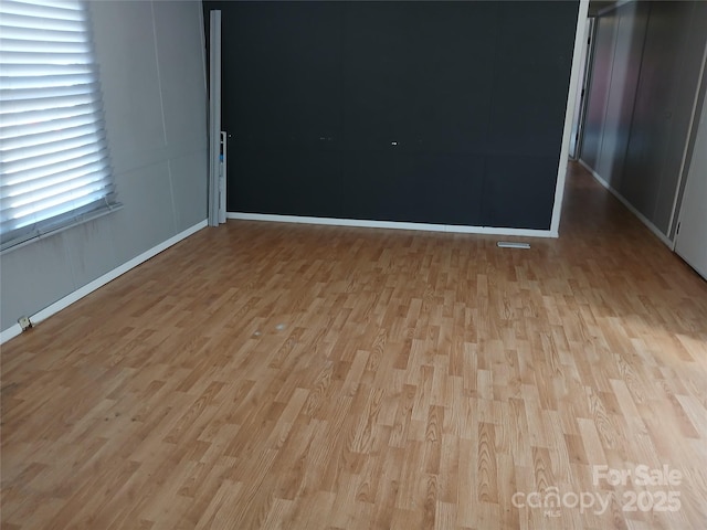 spare room with wood finished floors