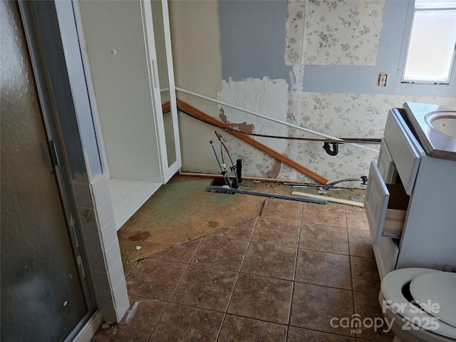 bathroom with wallpapered walls, vanity, and tile patterned flooring