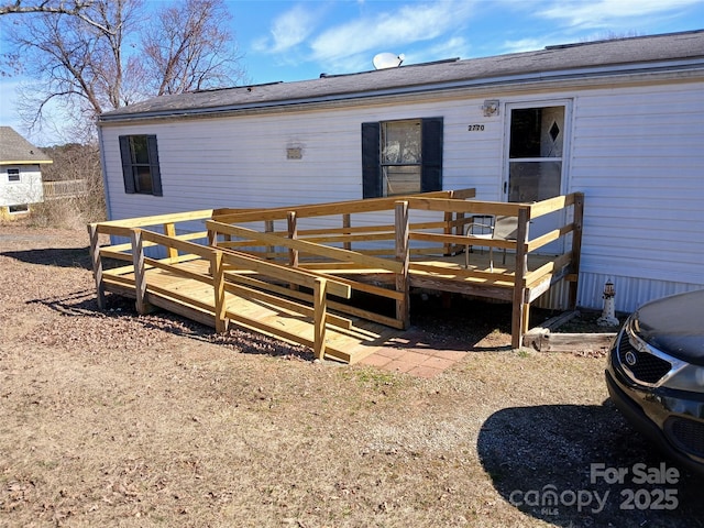 rear view of property featuring a wooden deck