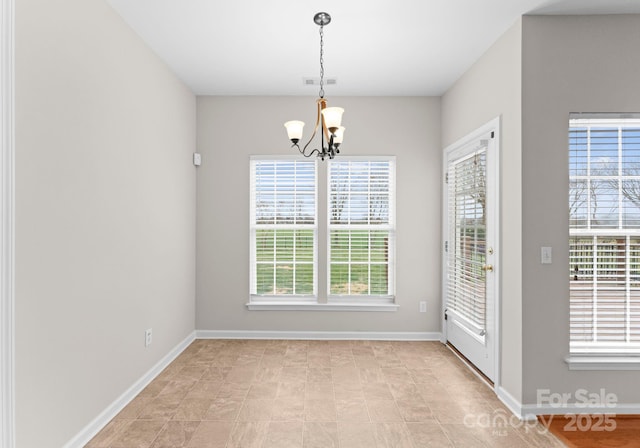 unfurnished dining area with an inviting chandelier, visible vents, and baseboards